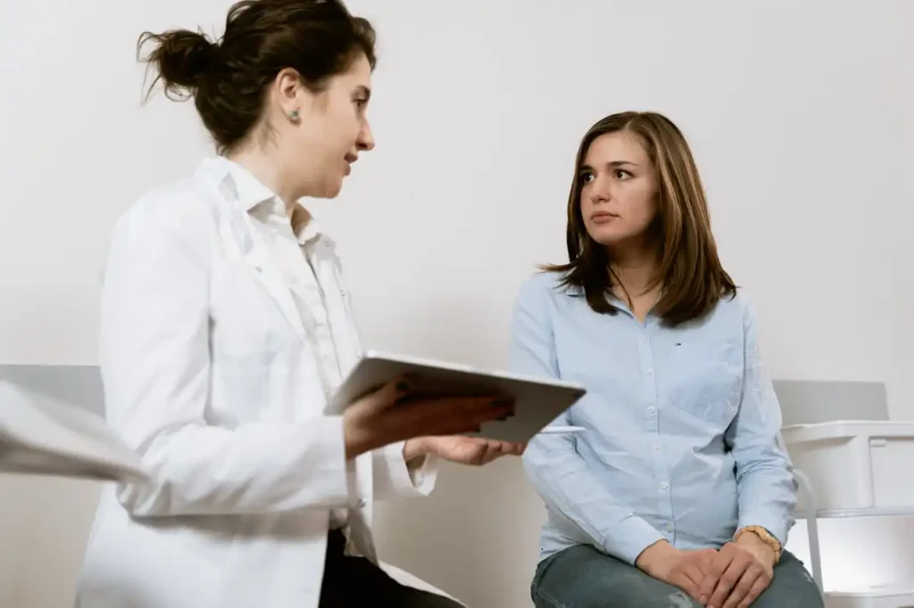 A doctor consults with a woman discussing healthcare options in a rehab facility