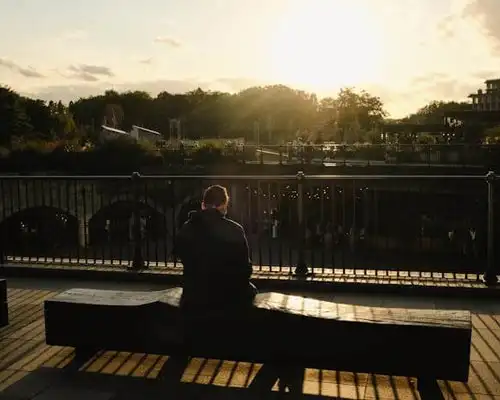 man sitting on a bench in park near Corona California