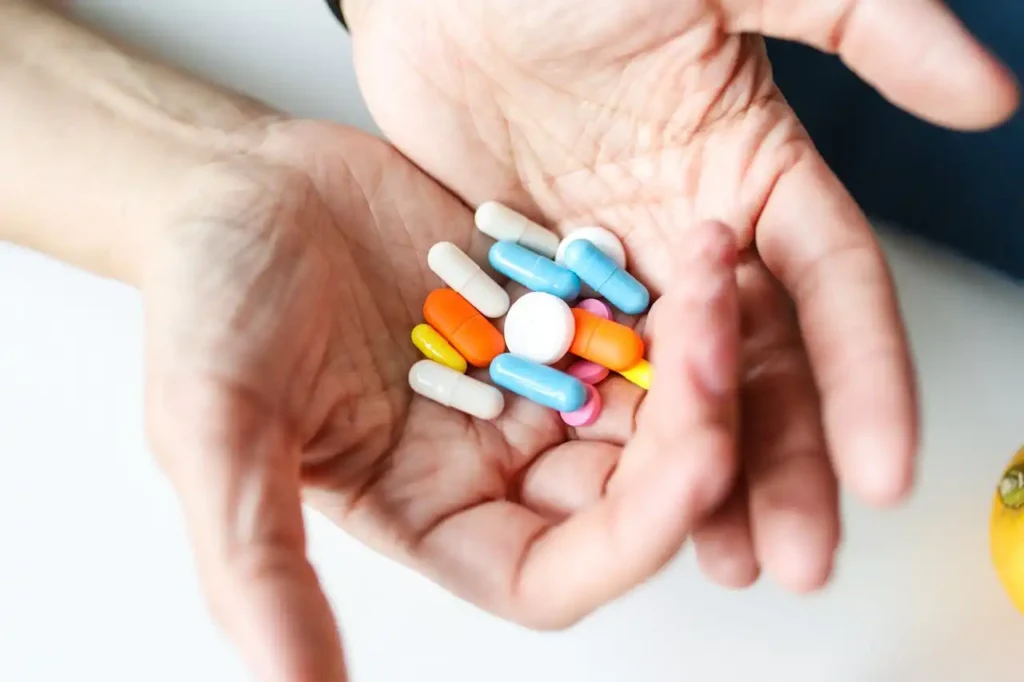 variety of medicines in a man's hands
