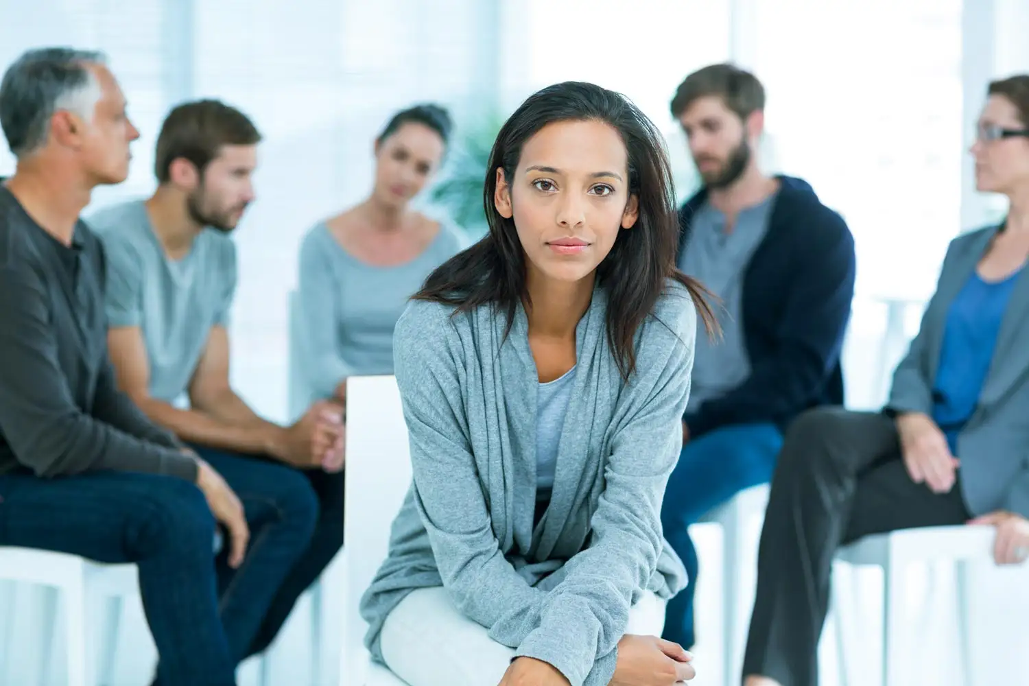 A woman seated before an audience, discussing drug detox options in Corona, Southern California, Riverside area.