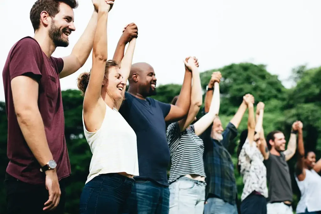 men and women outside drug and alcohol rehab in corona southern california holding hands together supporting each other in recovery