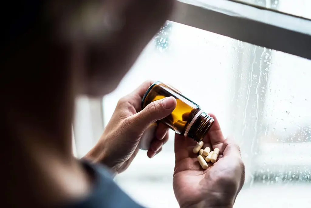 A woman pour some pills in her palm indicates overdose