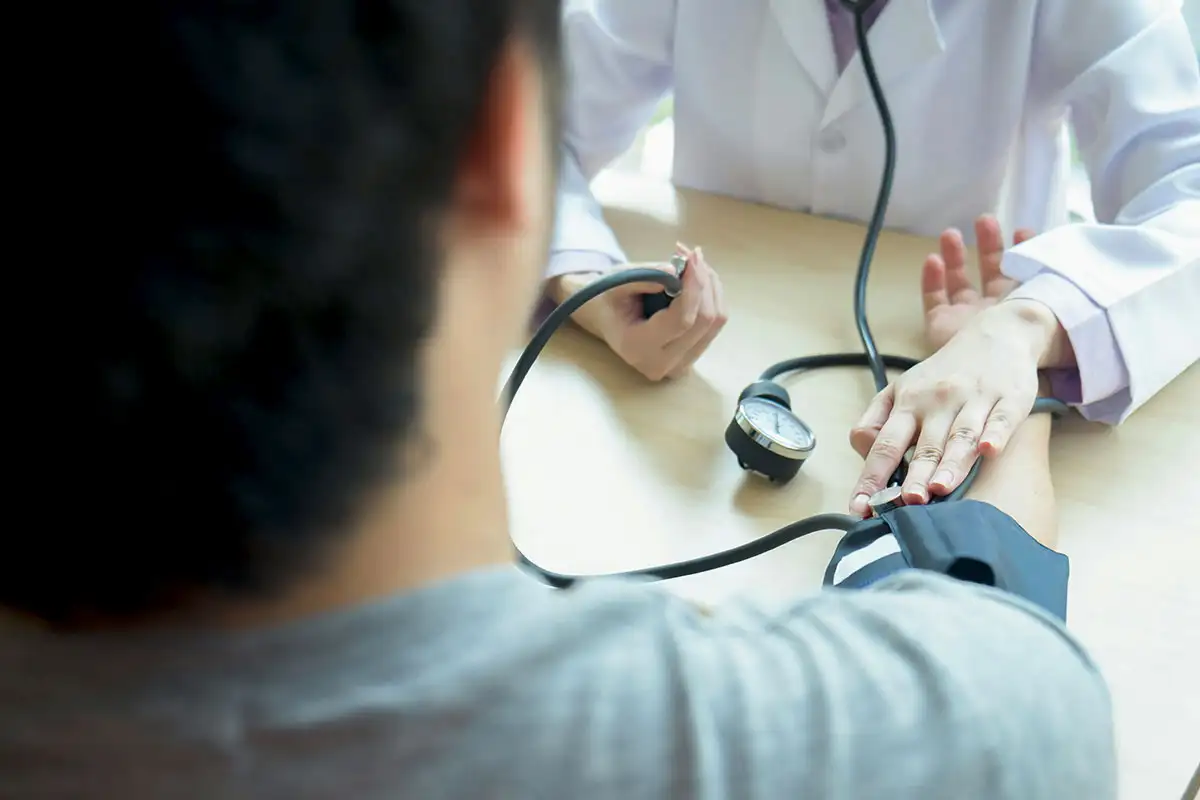 A doctor measures a patient's blood pressure during an inpatient detox for benzodiazepine withdrawal