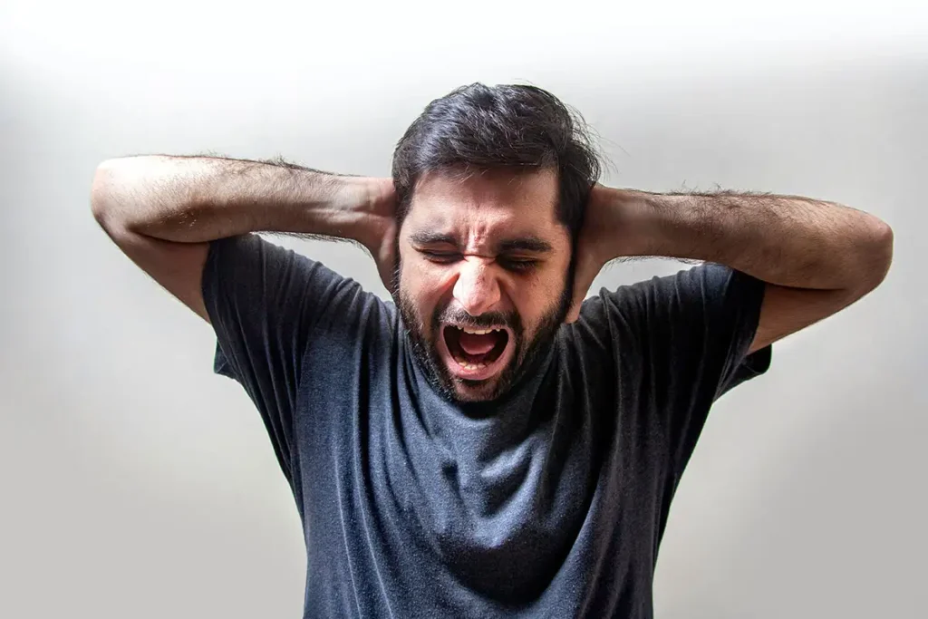 man with PTSD closing his ears