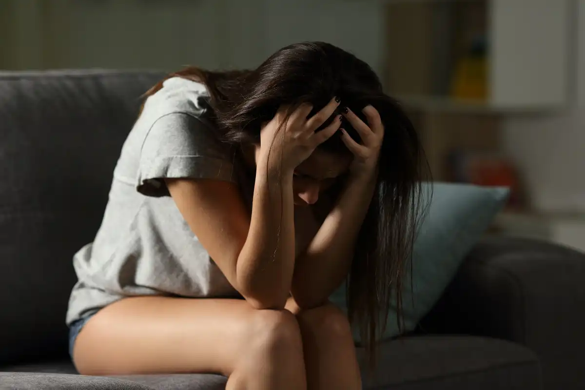 a woman sitting on a sofa suffering from anxiety