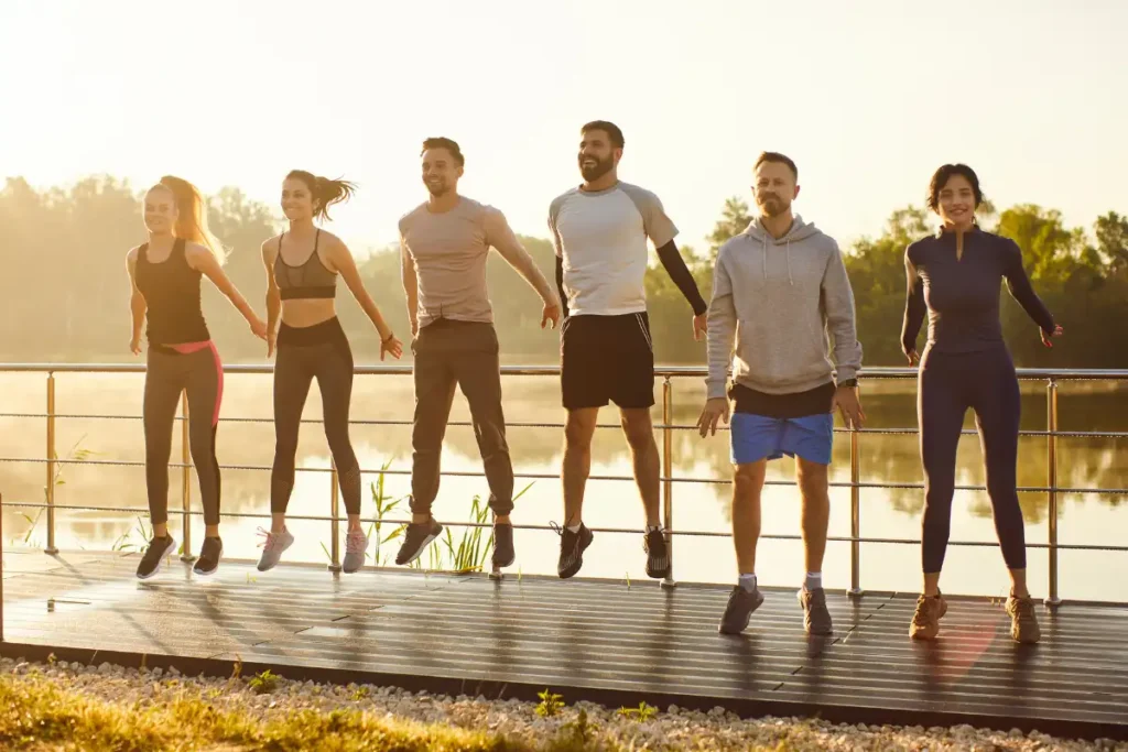 Group of six people doing dynamic warm-up exercises