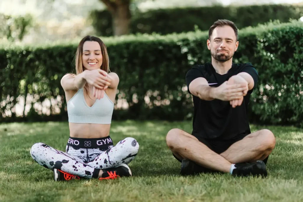 a woman and a man doing some stretching outdoor enjoying the warm weather in drug and alcohol rehab in corona california