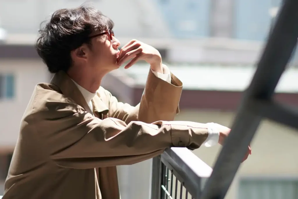 Thoughtful Man in Beige Trench Coat Pondering