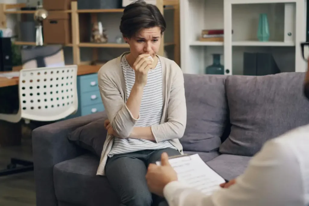A male psychologist sitting on a couch talking to a woman