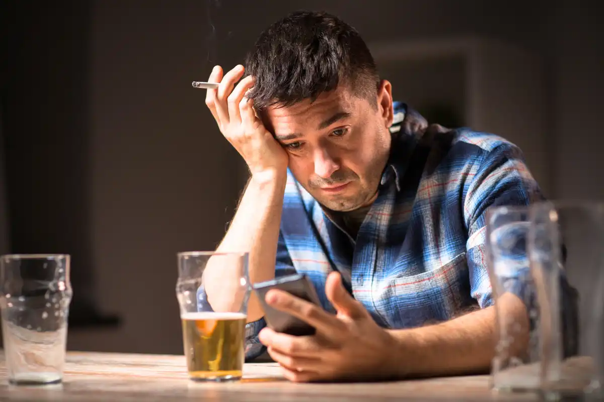 Man with Cellphone Drinking Alcohol and Smoking