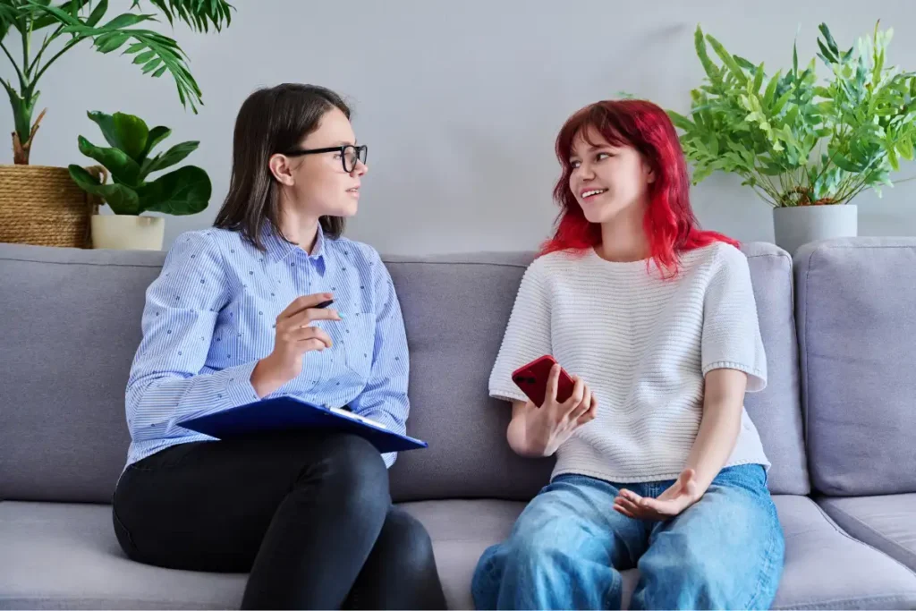Psychologist Counseling Teenage Female, Individual in Doctors Office.