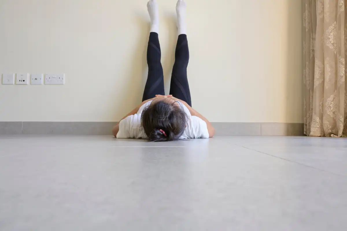 bored Woman laying on floor feet up on wall