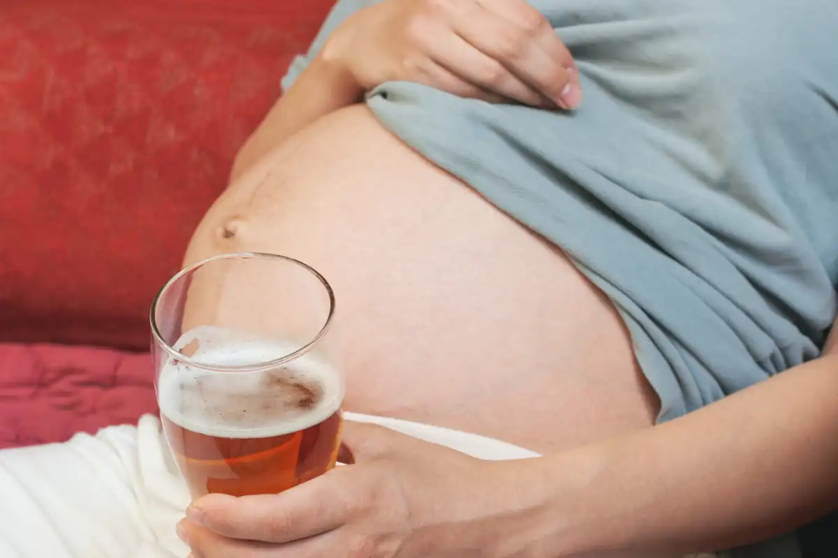Pregnant woman holding beer