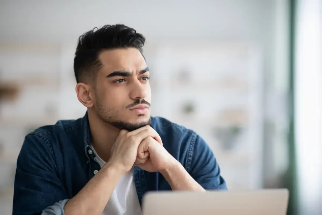 thoughtful man working on laptop