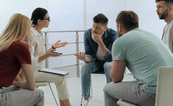 men and women during group therapy session